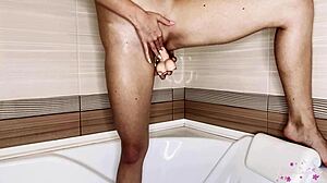 Brunette babe bereikt een orgasme met een dildo in de badkamer