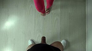 Sexede fødder i lyserøde sneakers sparker en bold i slowmotion